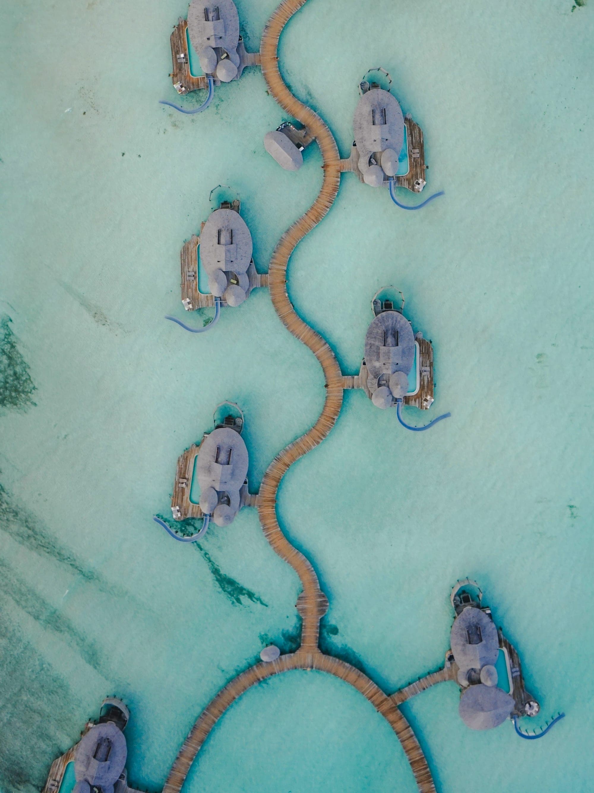 Overwater villas linked by wooden walkways across a still lagoon